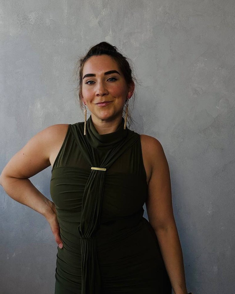 Handyfoto von Sarah Canenbley im dunkelgr&uuml;nen Kleid vor einer grauen Wand