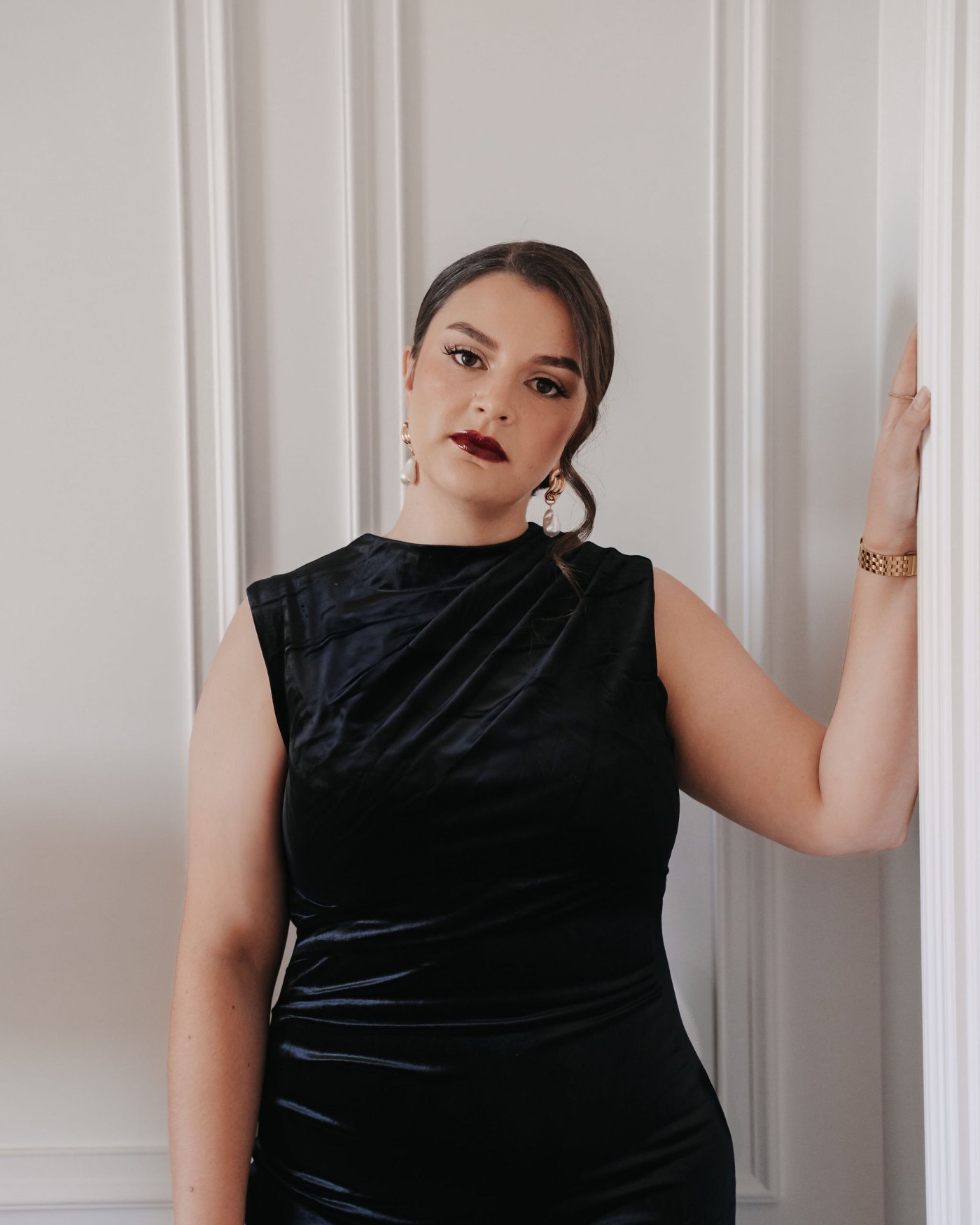 Editorial Cannes · stehend im schwarzen Kleid am Fenster
