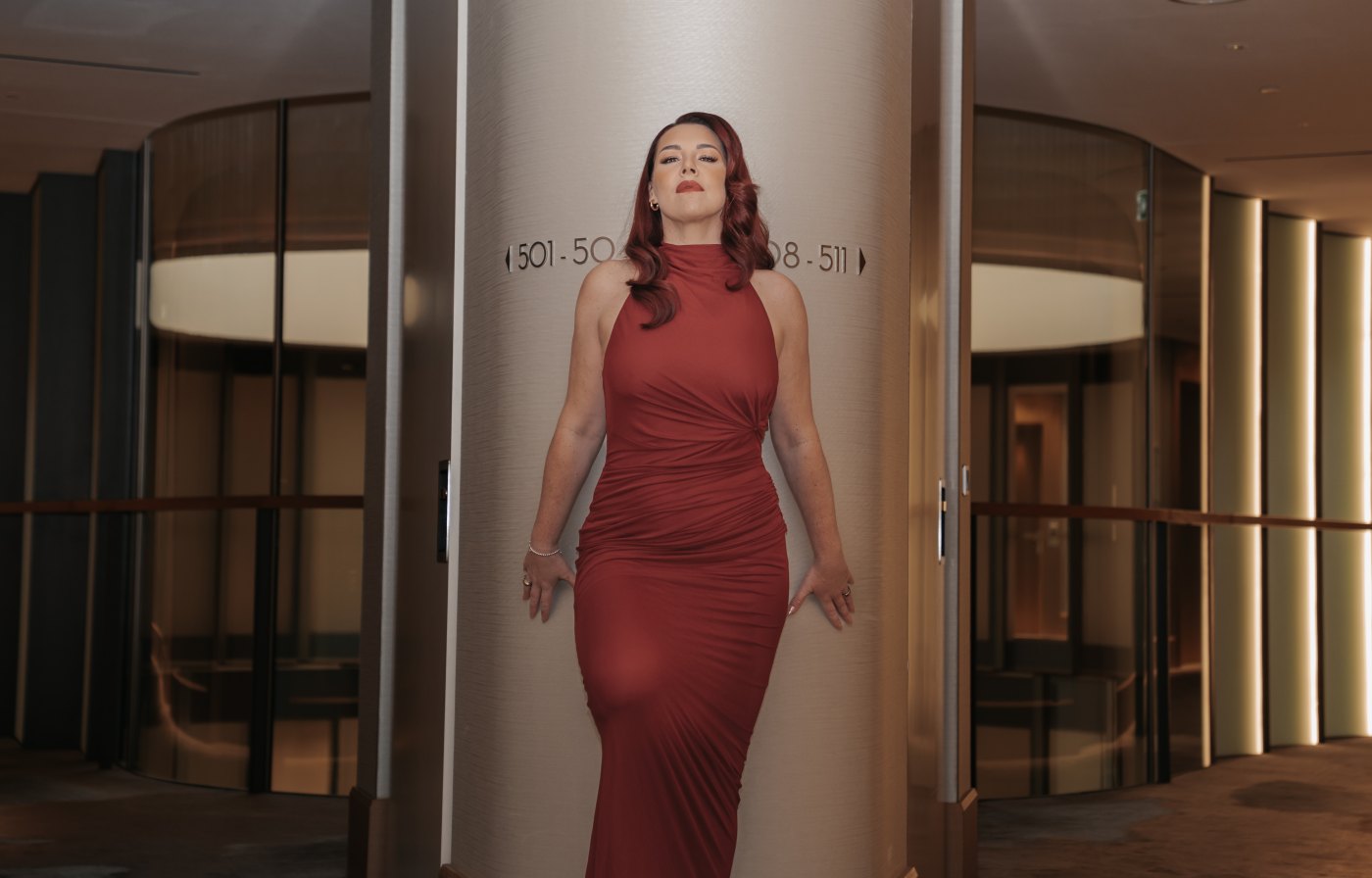 Corinna im roten Kleid in der Drehtür des Fontenay Hamburg