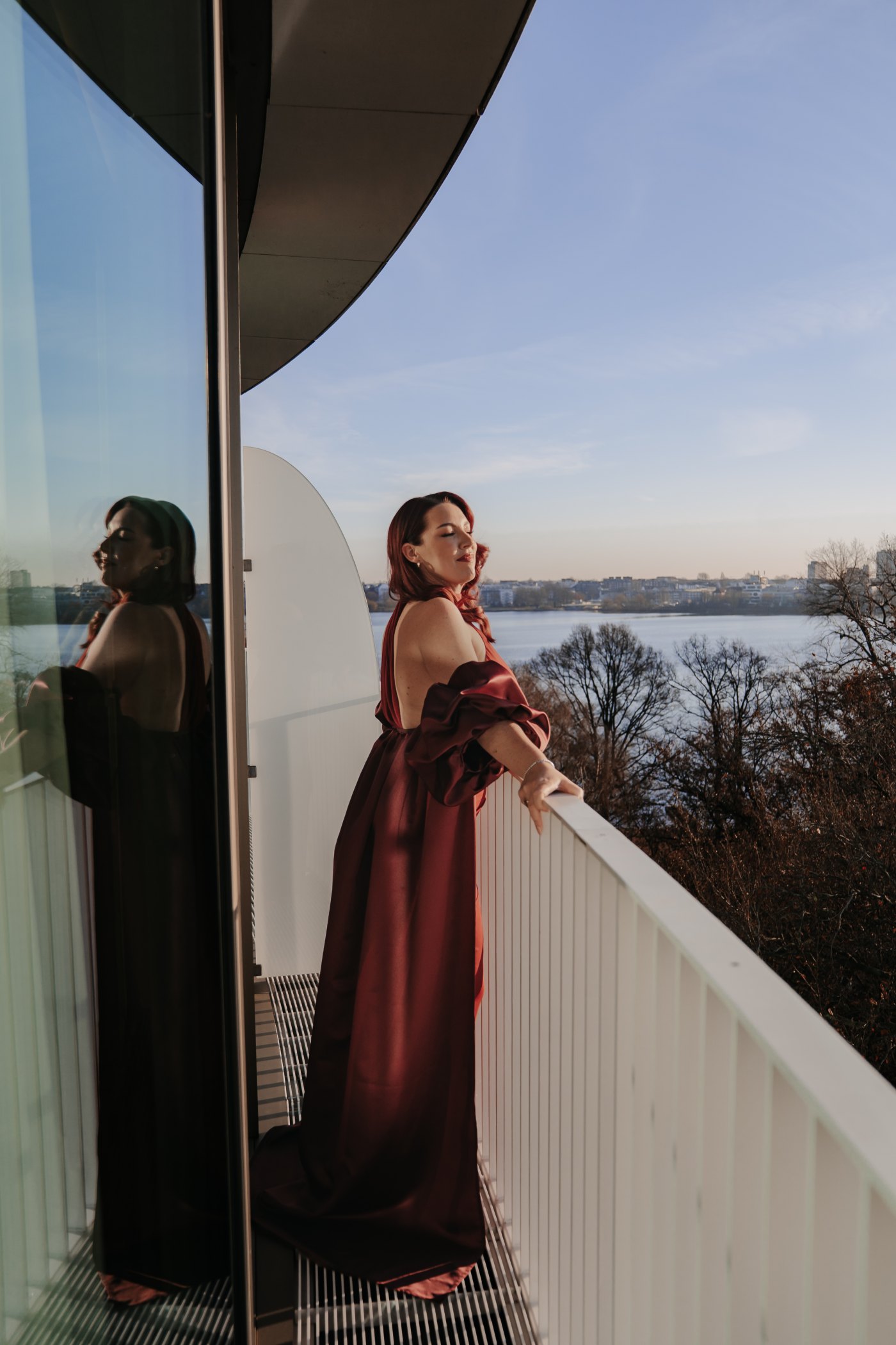 Editorial Hamburg · rotes Kleid am Balkon mit Blick über die Alster