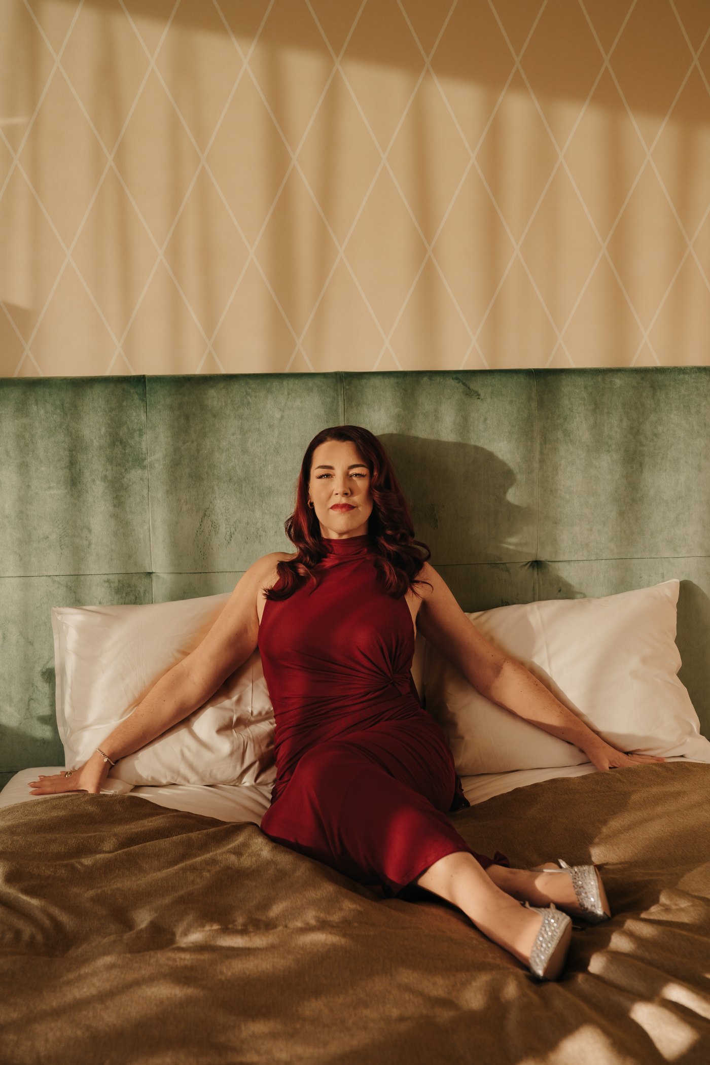 Corinna Moldenhauer im roten Kleid auf dem grünen Samtbett · Editorial im Fontenay Hamburg