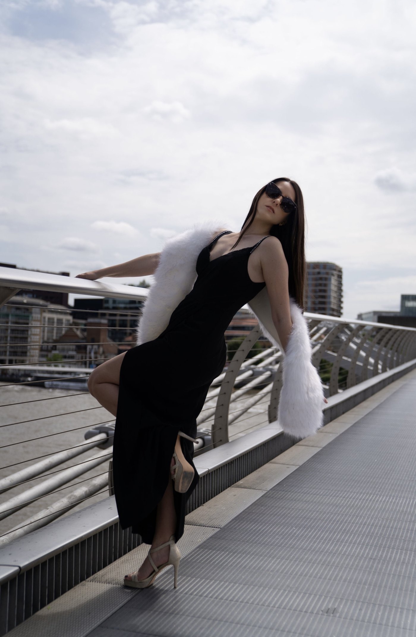 Editorial Shooting auf der Millennium Bridge London · schwarzes Kleid mit weißem Pelz vor St Pauls