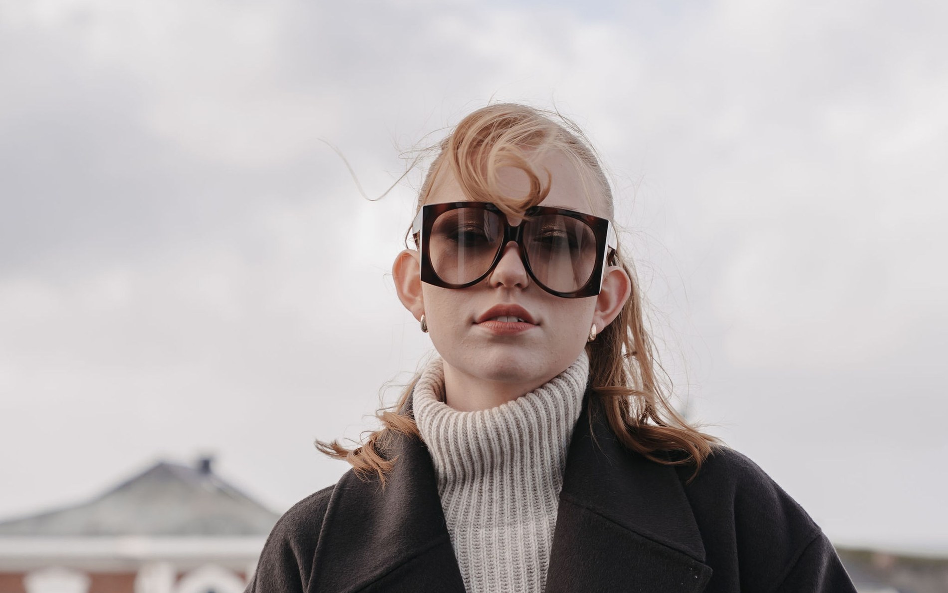High Fashion Editorial auf Sylt · Model mit XXL-Sonnenbrille im Mantel, fotografiert von Sarah Bakker