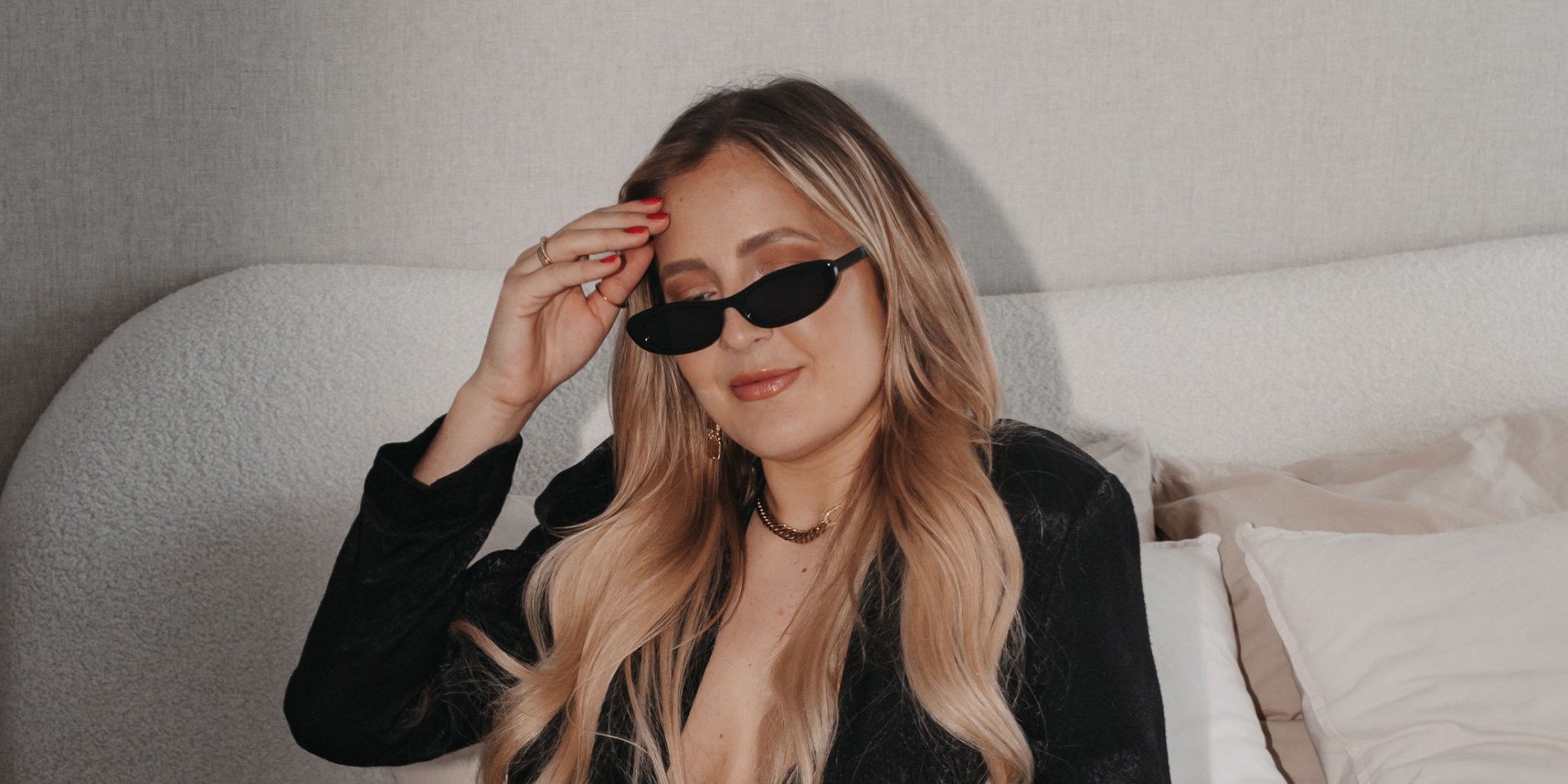 Editorial Shooting auf Mallorca · Daniela Riecken mit Sonnenbrille im schwarzen Blazer auf dem Bett