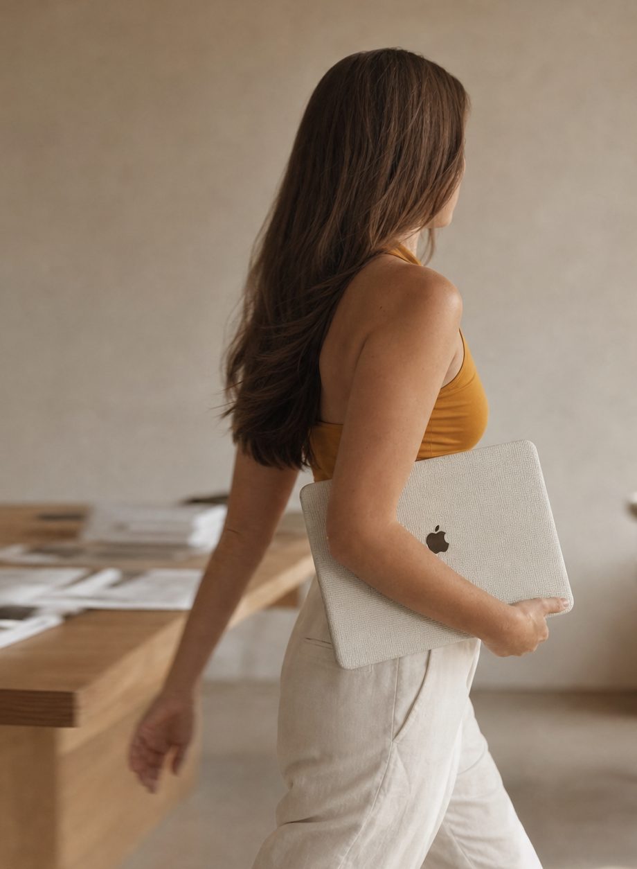 Sarah Bakker geht mit dem Laptop unter dem Arm durch ihr Studio